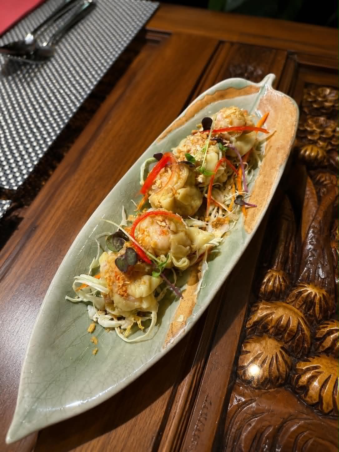 Prawn wontons served on a celadon leaf plate